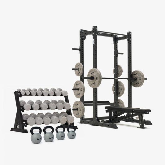 Utrustning för hemmagym med skivstångsställning, hantlar och kettlebells.