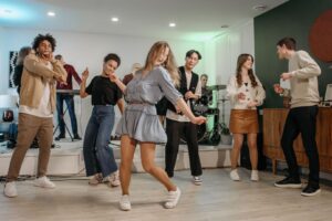 Vänner dansar framför ett band på en livlig hemmafest